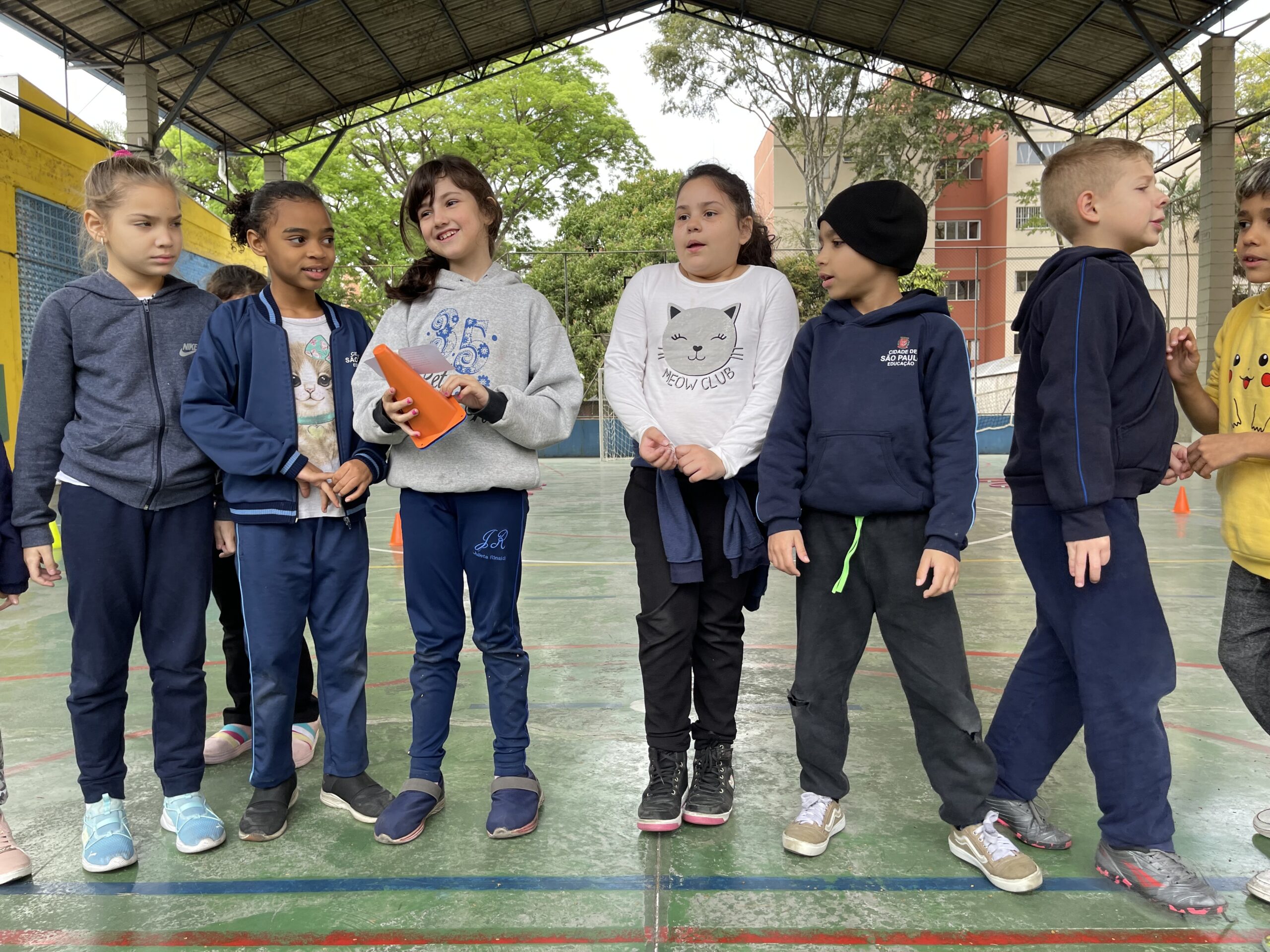 Crianças em atividades de alfabetização na quadra da escola