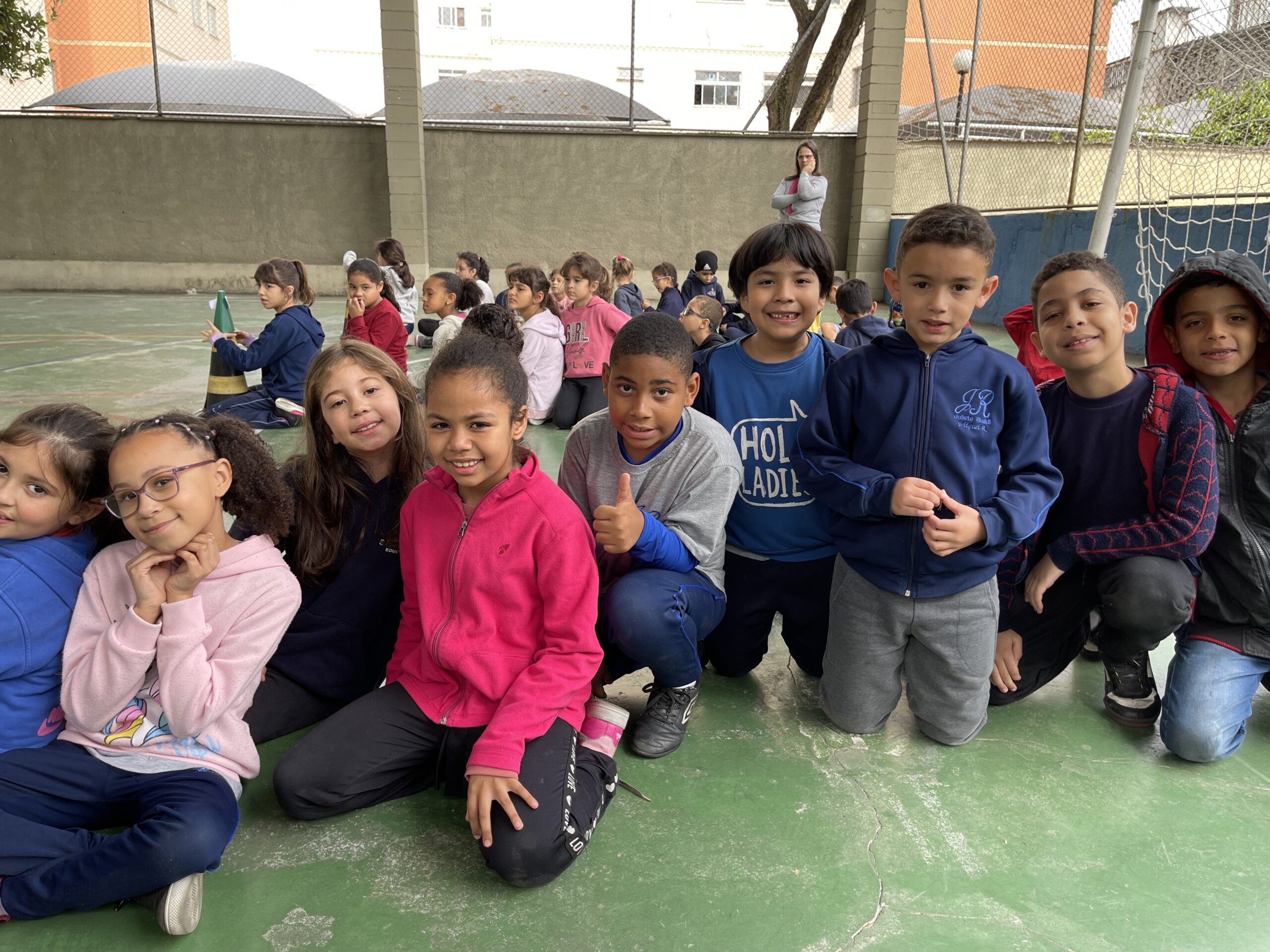 Crianças em atividades de alfabetização na quadra da escola